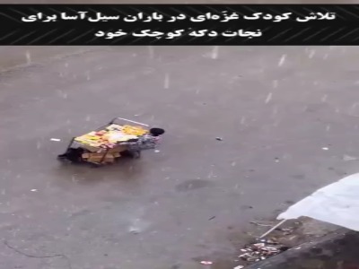 تلاش کودک غزه‌ای در باران سیل‌آسا برای نجات دکه کوچک خود